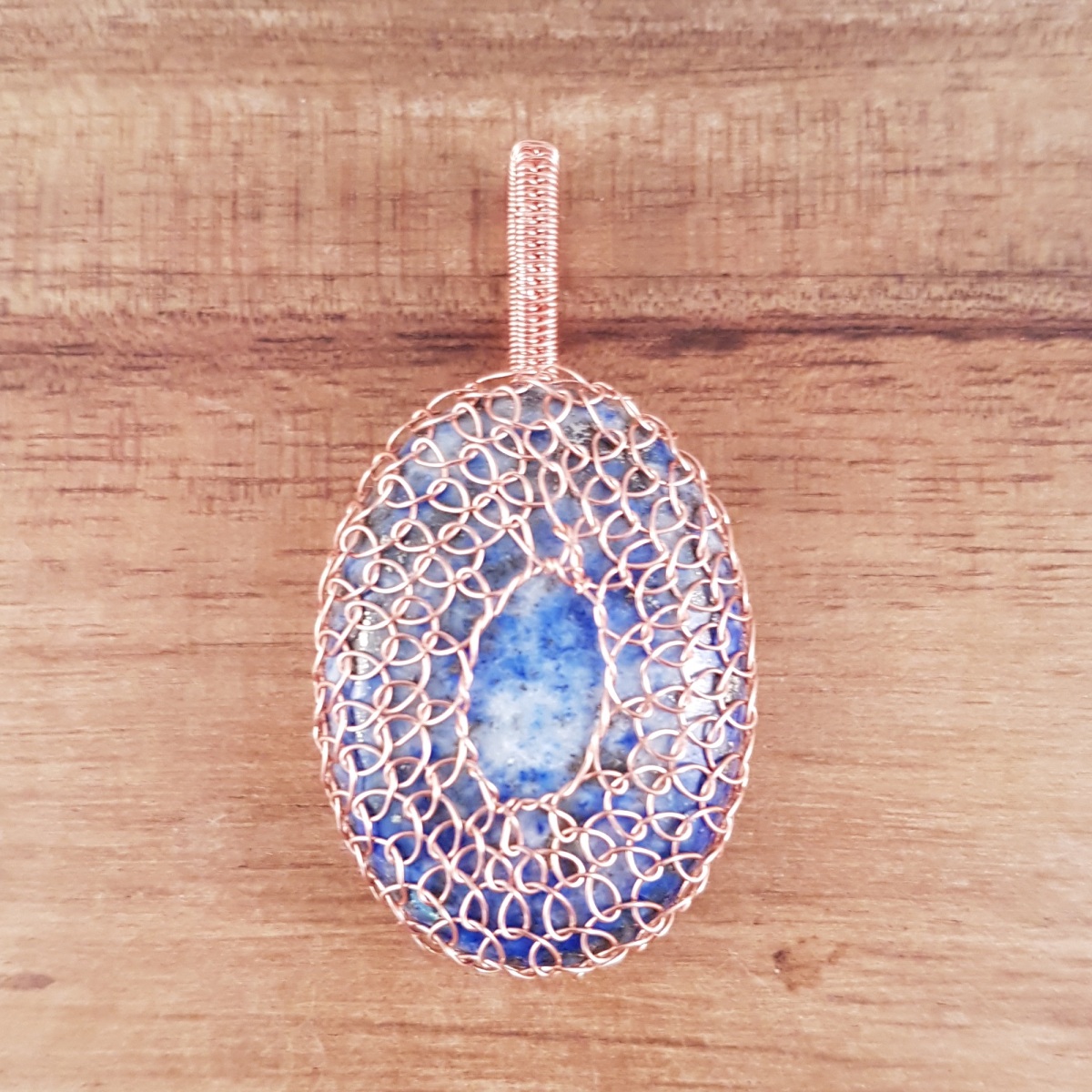 Lapis lazuli oval wrapped in rose gold coloured wire