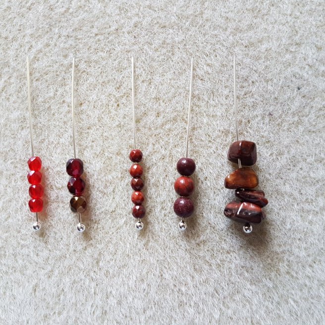 Various red gemstones and beads on silver headpins