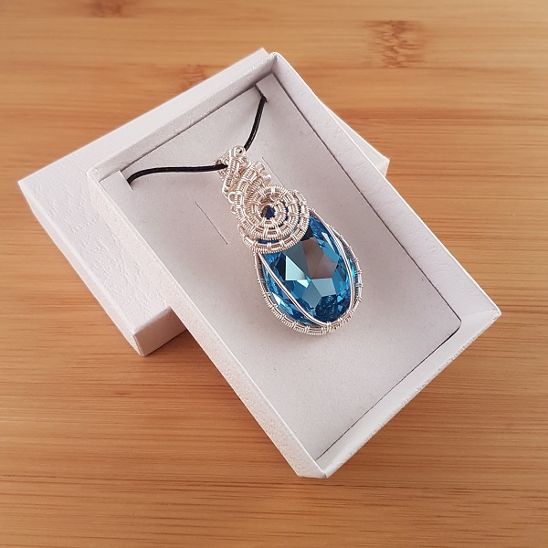 Light blue Swarovski pendant wrapped in silver wire in white box