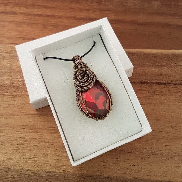 Red Swarovski pear drop wrapped in bronze wire in white box